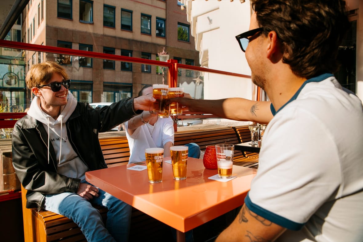 Bezoekers proosten met bierglazen van De Eeuwige Jeugd op het terras