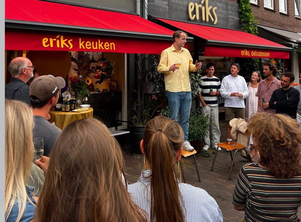 Koen van Keulen houdt een toespraak voor het pand tijdens de drukbezochte opening van Erik’s Keuken