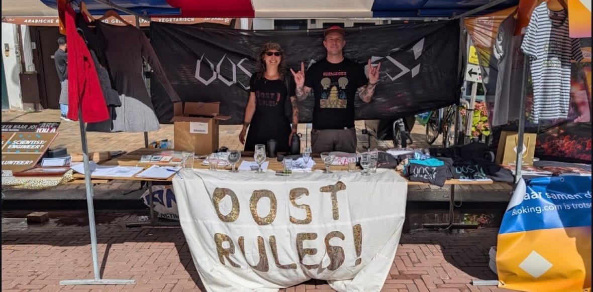Twee vrijwilligers van Oost Rules bij hun kraam op het Indische Buurt Festival
