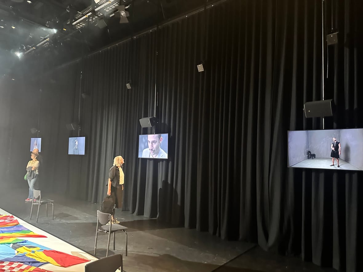 Bezoekers bekijken de videoschermen met persoonlijke verhalen in de installatie Unfolded Voices