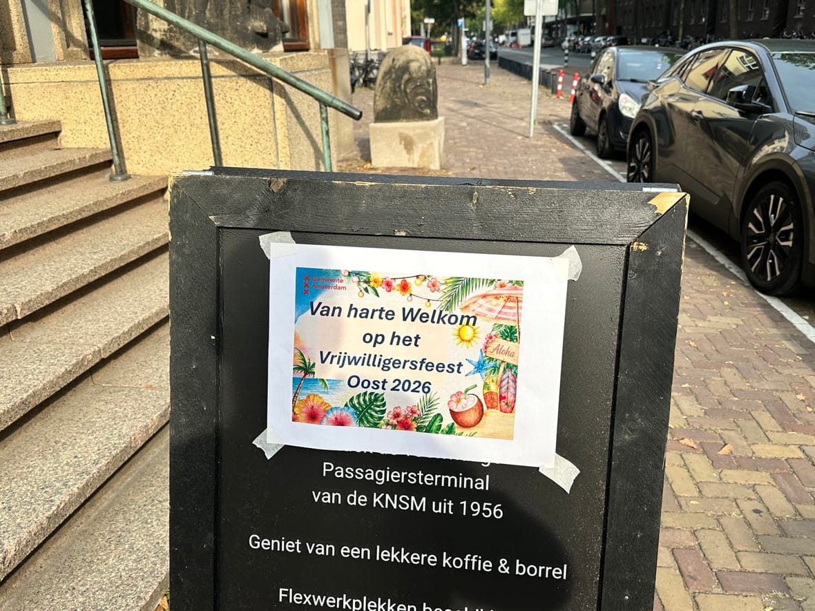 Aankondigingsbord bij de ingang: ‘Van harte welkom op het Vrijwilligersfeest Oost 2026’, in de voormalige passagiersterminal van de KNSM uit 1956