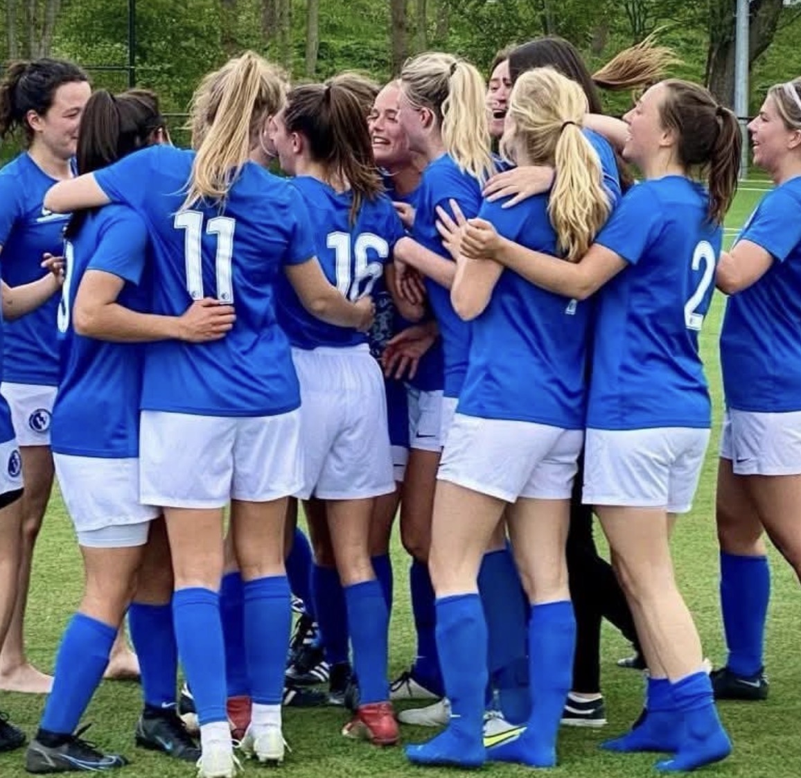 Speelsters van WV-HEDW omhelzen elkaar juichend na een doelpunt